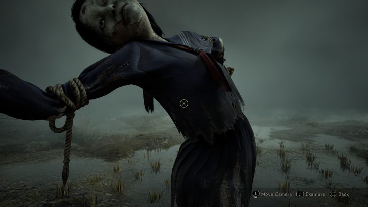 A doll-like figure in a tattered blue outfit is tied up in a desolate landscape with on-screen text: Move Camera L1 Examine Back.