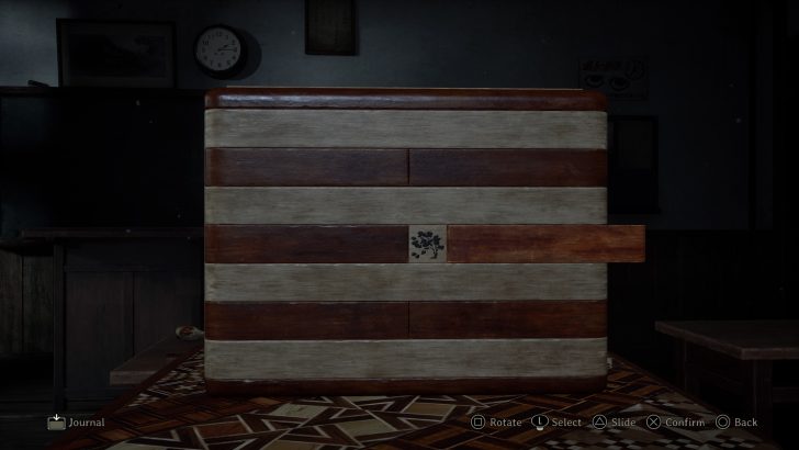 Wooden puzzle box on table with “rotate” and “slide” instructions on screen.